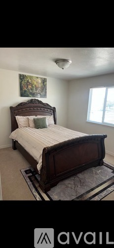 A bedroom with a large bed and a window.