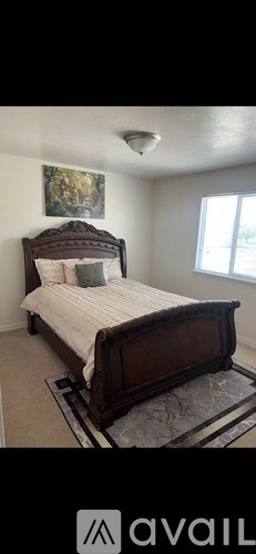 A bedroom with a large bed and a window.