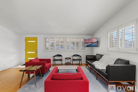 A living room with a red couch and a television.