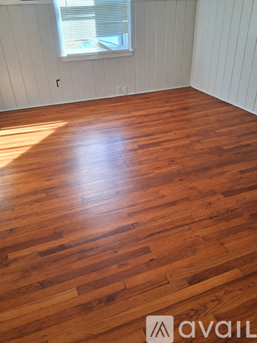 A hallway with wood floors and white walls.