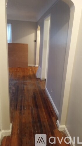 A room with a white wall and a brown door.