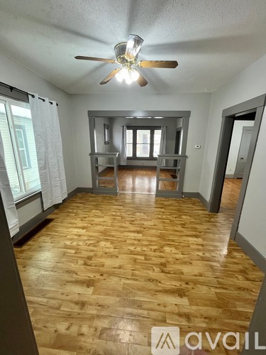A room with wooden flooring and a ceiling fan.