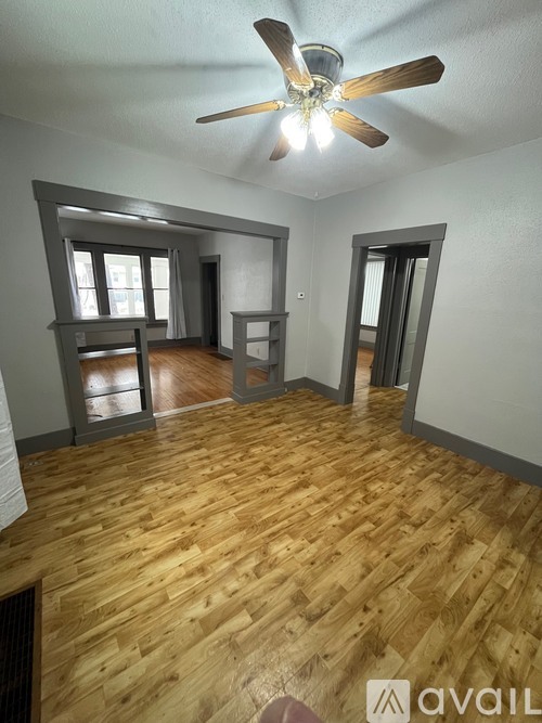 A room with wooden floors and a ceiling fan.