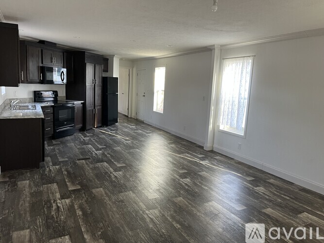 A kitchen with black cabinets and a black refrigerator.