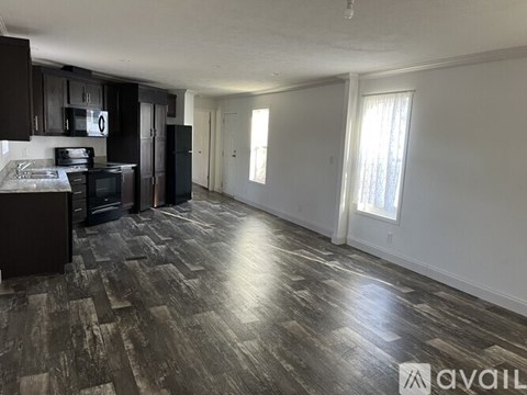 A kitchen with black cabinets and a black refrigerator.