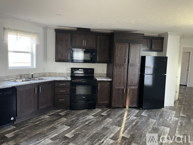 A kitchen with dark wood cabinets and appliances.