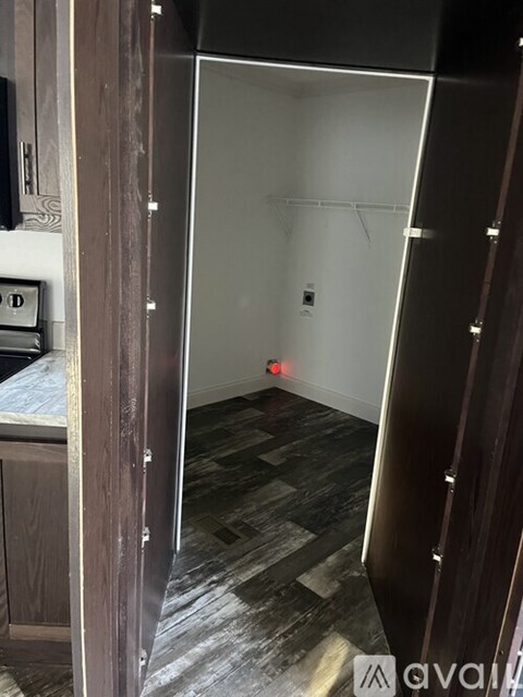 A room with a white wall and a wooden floor.