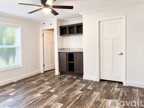 A white wall with a white door and a white shelf.