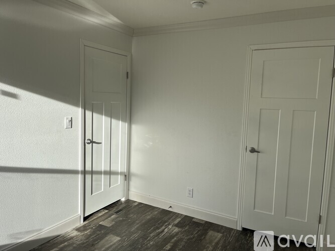A room with two doors and a wooden floor.