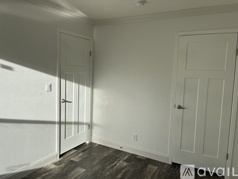 A room with two doors and a wooden floor.