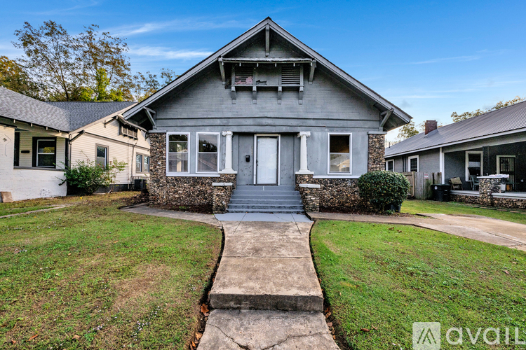 A house with a grey front yard and a stone pathway leading to the front door.