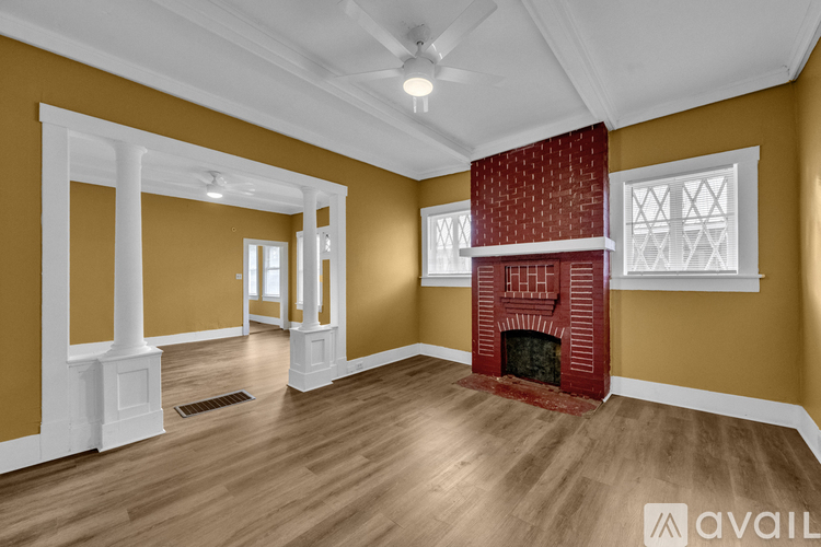 A living room with a fireplace and a ceiling fan.