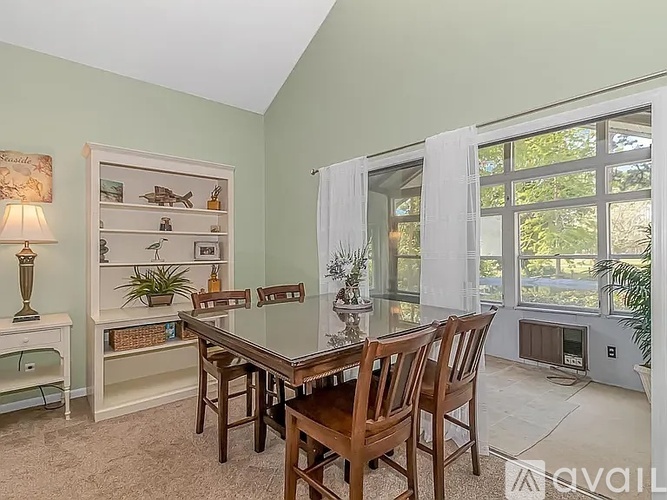 A dining room with a table and chairs.