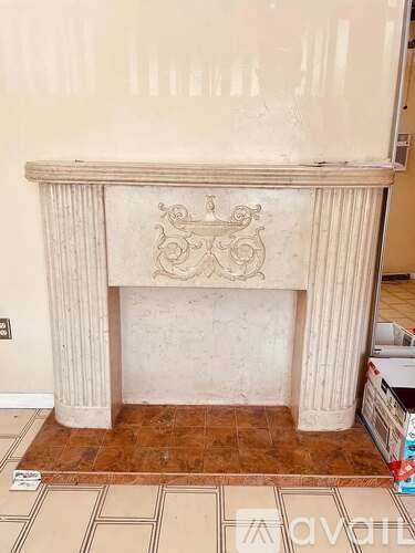 A fireplace with a carved design on the mantle.