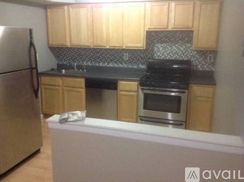 A kitchen with wooden cabinets and a black stove top oven.