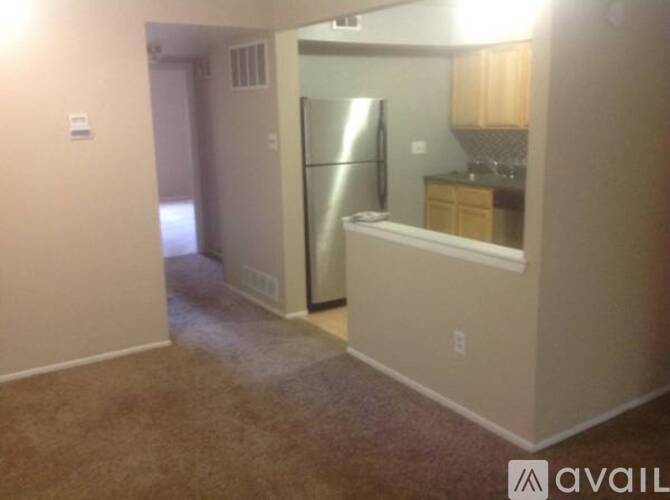 A kitchen area with a refrigerator, sink, and cabinets.