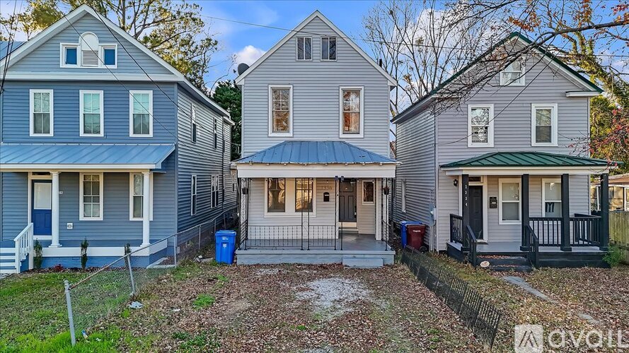 Three houses with different front yards and one with a blue door.