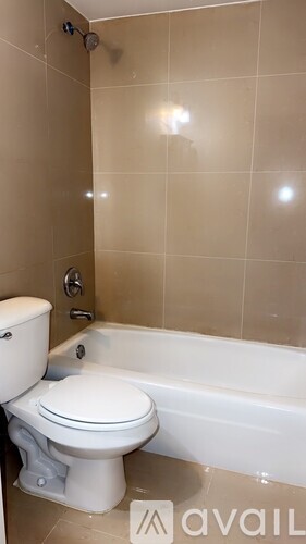 A white toilet sits next to a bathtub in a bathroom.