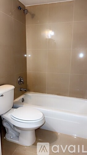 A white toilet sits next to a bathtub in a bathroom.