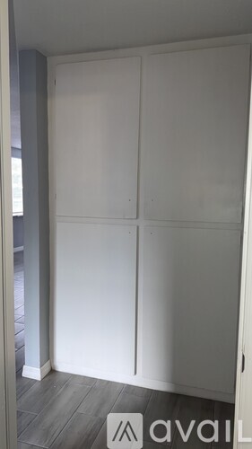 A white wardrobe with four doors is in a room.