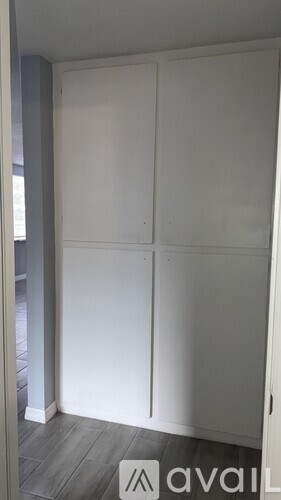 A white wardrobe with four doors is in a room.