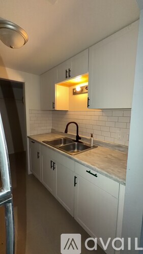 A kitchen with white cabinets and a sink under a window.