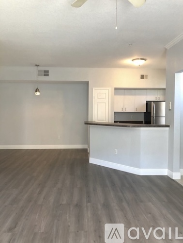 A kitchen area with a refrigerator and cabinets.
