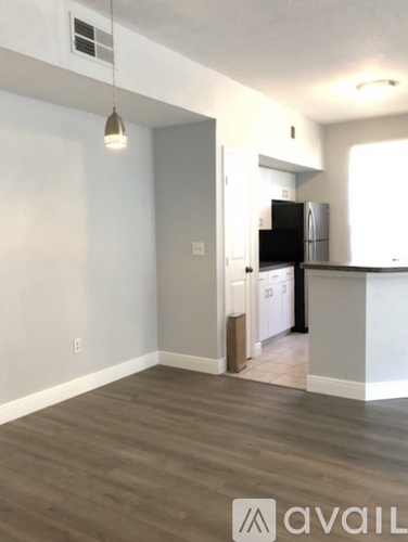 A kitchen area with a refrigerator, cabinets, and a countertop.