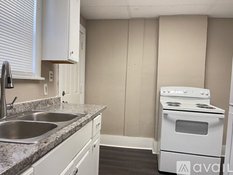 A kitchen with a white stove and sink.