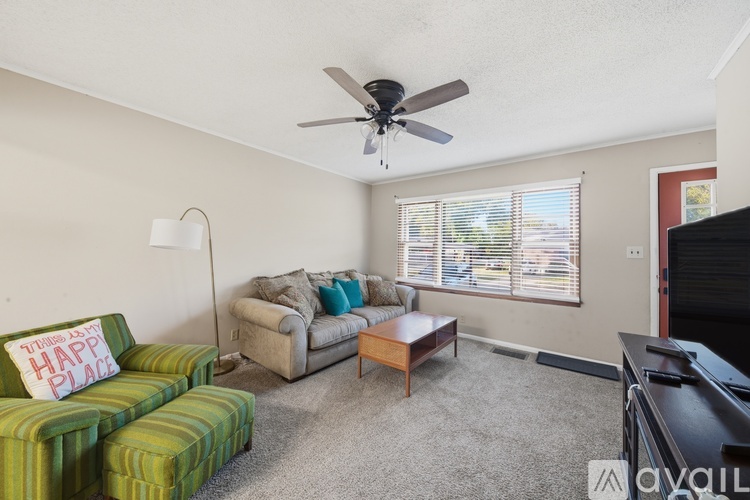 A living room with a green couch and a sign that says "Happy Place".