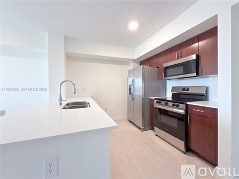 A kitchen with white countertops and stainless steel appliances.