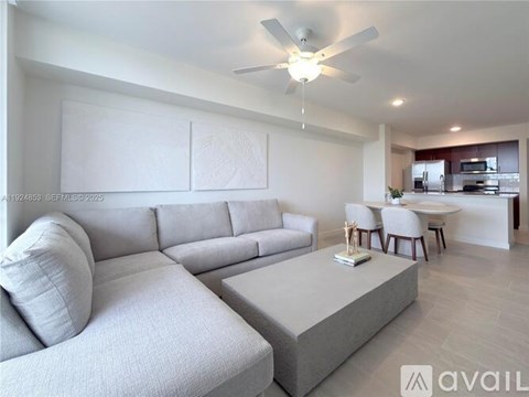 A modern living room with a grey sofa and a white coffee table.