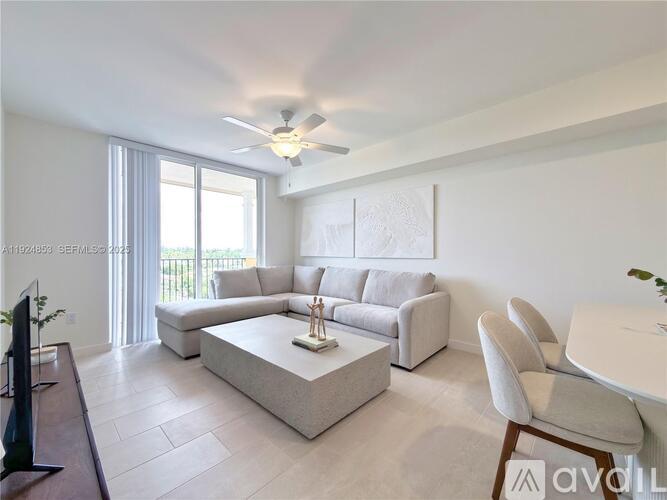 A living room with a white couch, a coffee table, and a ceiling fan.