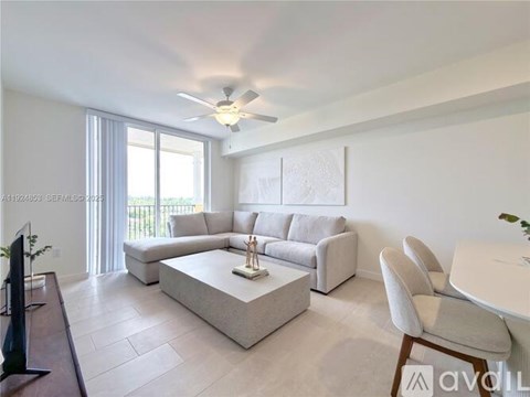 A living room with a white couch, a coffee table, and a ceiling fan.