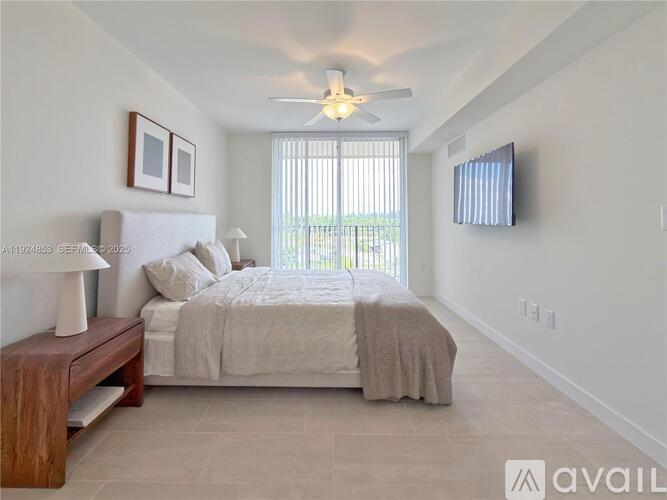 A bedroom with a large bed, a bench, and a ceiling fan.