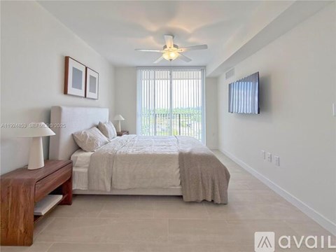 A bedroom with a large bed, a bench, and a ceiling fan.