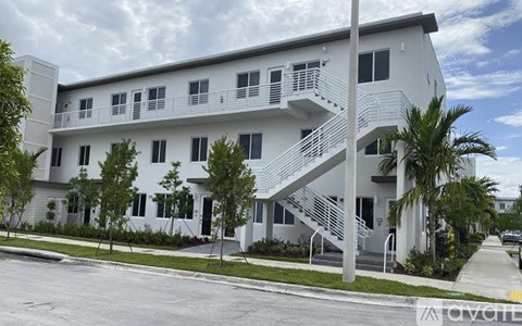 A white building with a balcony and stairs.