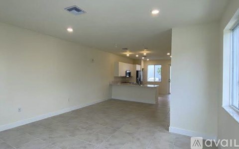 A spacious empty room with a counter and a window.