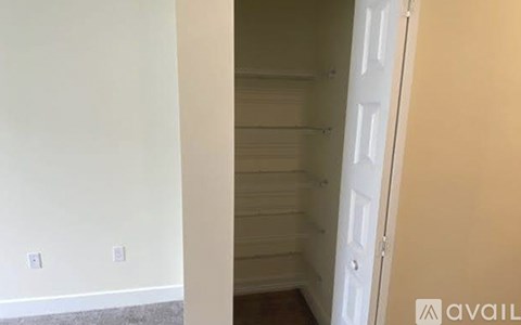 A white door is in a room with a white wall and a wooden floor.