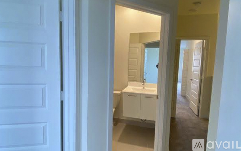 A white bathroom with a toilet, sink, and mirror.