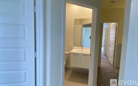 A white bathroom with a toilet, sink, and mirror.