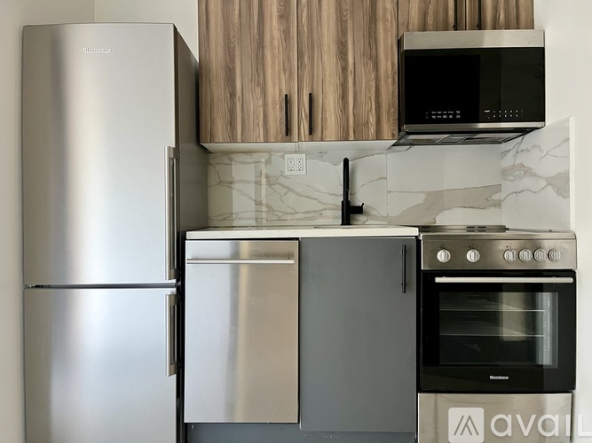 A kitchen with a stainless steel refrigerator, oven, and microwave.