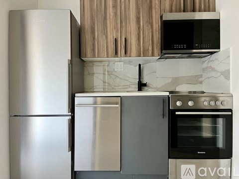 A kitchen with a stainless steel refrigerator, oven, and microwave.