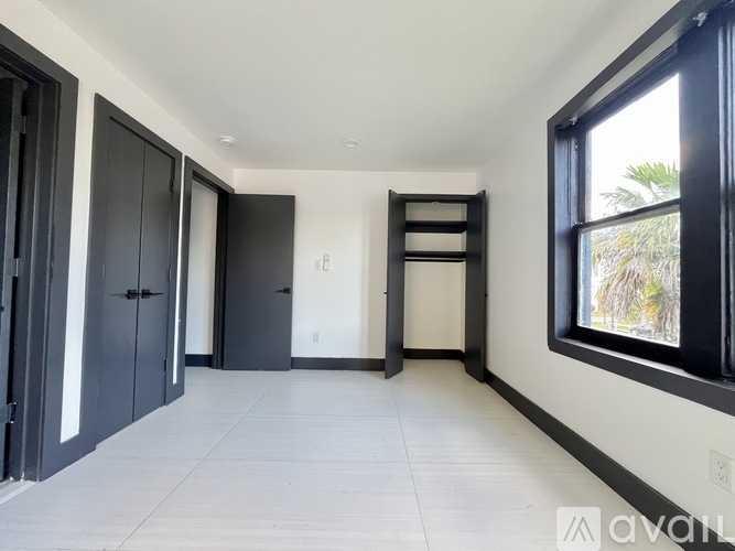 A spacious room with black doors and a ladder in the corner.