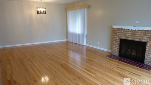 A room with a fireplace and wooden floors.