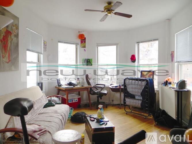 A living room with a couch, chair, and a fan.