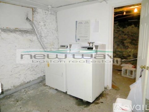 A room with a white fridge and a sign on the wall.