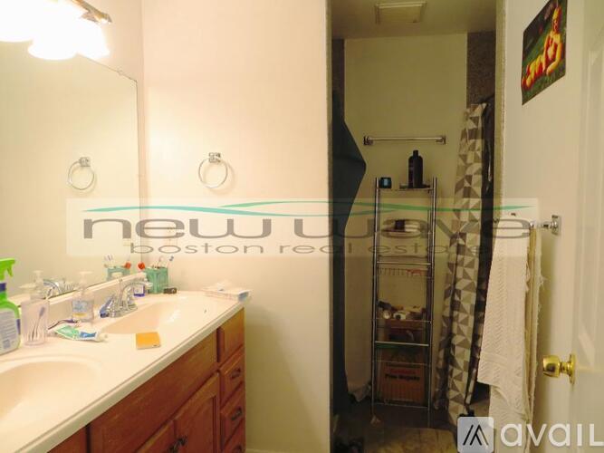 A bathroom with a sink, mirror, and a shower stall.