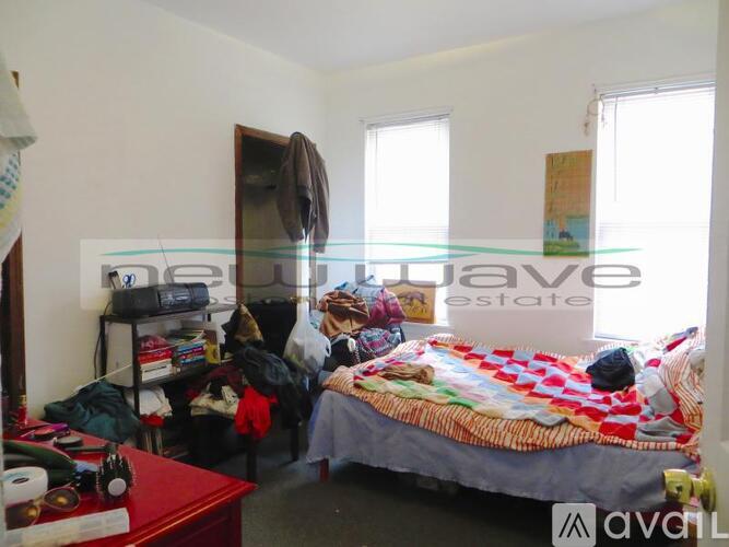 A bedroom with a bed, a dresser, and a window.