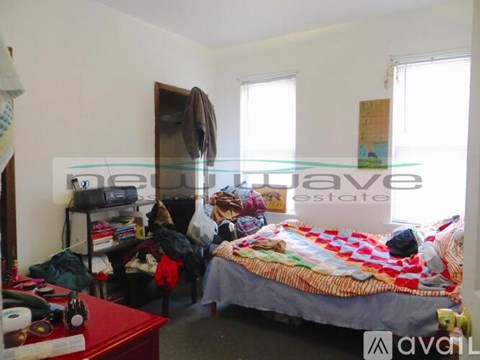 A bedroom with a bed, a dresser, and a window.